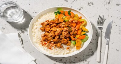 Kip in zoete sojasaus met pikante honingpinda's met sticky knoflookrijst, paksoi en wortel