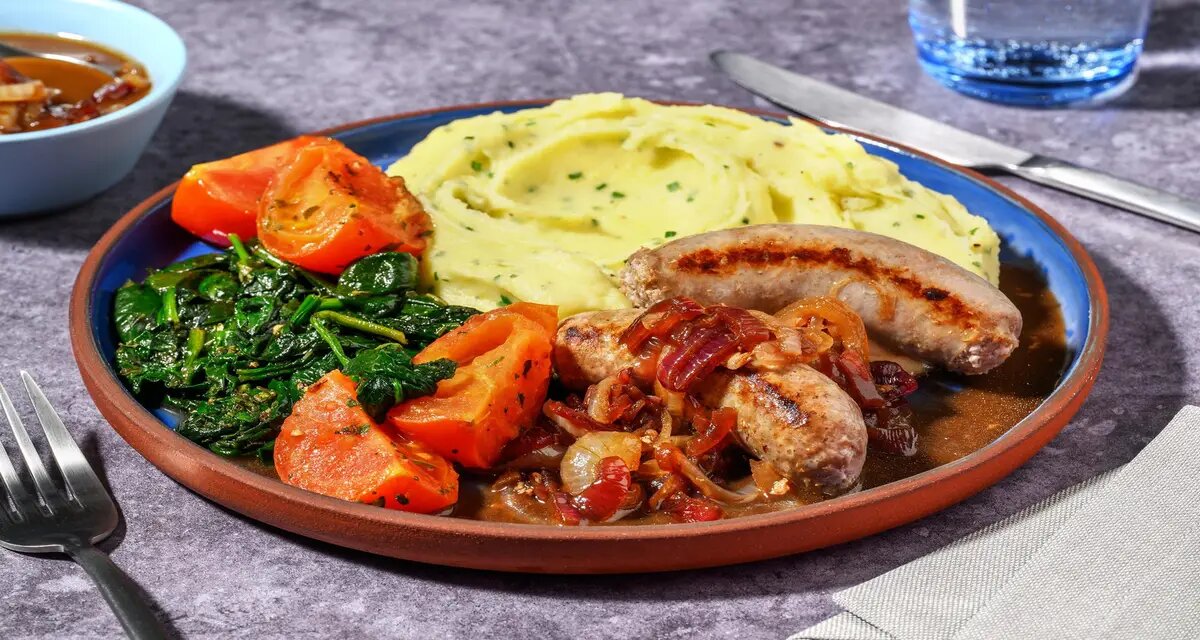 Varkensworstjes met bieslook-aardappelpuree met uienchutney, spinazie en knoflooktomaten