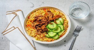 Stir-fry met biefstukreepjes in oestersaus met noedels en zoetzure komkommer