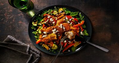 Gepaneerde kip met feta en zwarte sesamzaadjes met rucola, balsamicocrème en geroosterde groenten