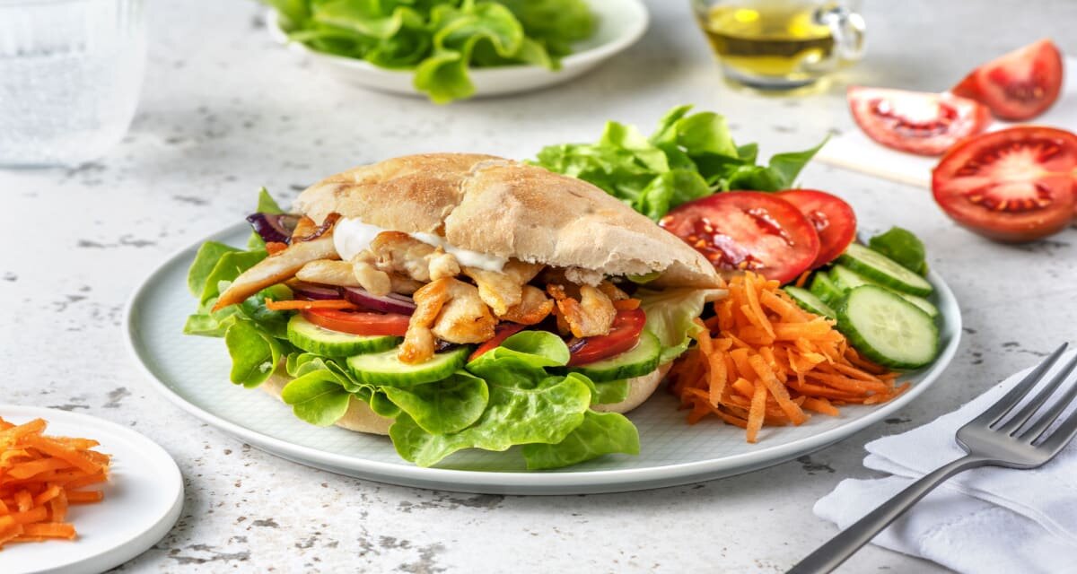 Broodje kipgyros met aioli met knapperige salade van komkommer, wortel en tomaat