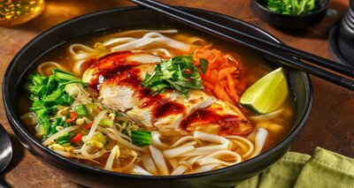 Pho-stijl noedelsoep met kip met paksoi, taugé, limoen en verse kruiden